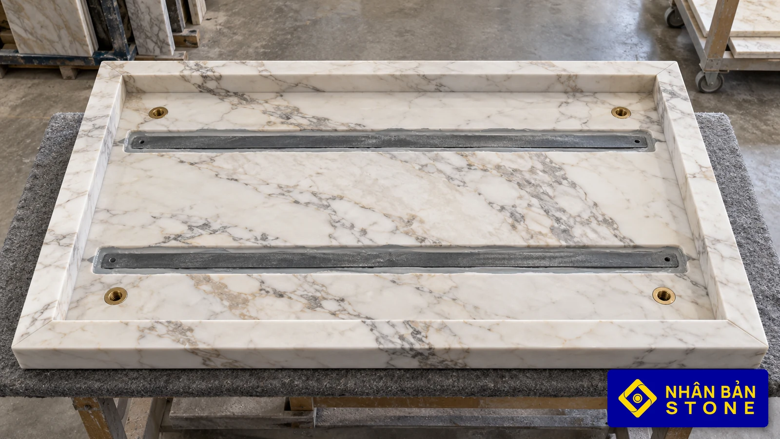 Illustrative image: Underside of stone tabletop with reinforcement channels, mitered apron, and brass threaded inserts – NHAN BAN STONE
